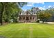 Charming two-story home with brick accents, a front porch, and beautiful landscaping in daylight at 654 Cannon Rd, Sharpsburg, GA 30277