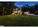 Elegant two-story home with a large front porch, brick accents, and lush landscaping at twilight at 654 Cannon Rd, Sharpsburg, GA 30277