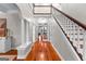 Hallway featuring staircase, columns, hardwood floors, and an opening to another room at 654 Cannon Rd, Sharpsburg, GA 30277