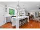 Open kitchen with white cabinetry, island with seating, and views to the living room at 654 Cannon Rd, Sharpsburg, GA 30277