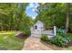 Charming outbuilding surrounded by lush landscaping and a stone pathway at 654 Cannon Rd, Sharpsburg, GA 30277