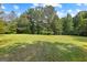 Expansive, well-maintained grassy yard surrounded by a lush, green tree line at 654 Cannon Rd, Sharpsburg, GA 30277