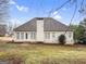 View of the back of the home with manicured landscaping, neutral siding, windows, and chimney at 9135 Woodhaven Way, Mcdonough, GA 30253