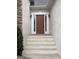 Close-up of the front door entrance with white trim and a brown door, framed by sidelights and an inviting porch at 9135 Woodhaven Way, Mcdonough, GA 30253