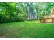 Verdant backyard offering mature trees, manicured lawn, and a wooden deck at 70 Sylvia Cir, Covington, GA 30016