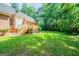 Wide backyard offering grass lawn, established trees, and a wooden deck and staircase at 70 Sylvia Cir, Covington, GA 30016