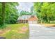 Charming brick home with a two-car garage and a long driveway surrounded by mature trees and a lush lawn at 70 Sylvia Cir, Covington, GA 30016