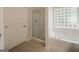 Bathroom featuring a soaking tub with tiled floors and large door at 70 Sylvia Cir, Covington, GA 30016