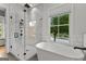 This elegant bathroom offers a standalone tub with a glass-enclosed shower featuring white marble tile at 185 Central Ave, Fayetteville, GA 30214