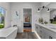 This stylish bathroom features a standalone tub, a double vanity, and a view into the bedroom at 185 Central Ave, Fayetteville, GA 30214