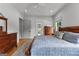 This cozy bedroom features beautiful hardwood floors, neutral walls, a ceiling fan, and warm lighting at 185 Central Ave, Fayetteville, GA 30214