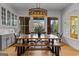 Bright dining room features a wood table, bench seating, a stylish light fixture, and a bar area at 185 Central Ave, Fayetteville, GA 30214