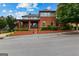 Inviting brick home boasts a covered porch, meticulous landscaping, and American flag, creating curb appeal at 185 Central Ave, Fayetteville, GA 30214