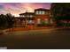 Stunning two-story brick home with manicured landscaping and an inviting front porch under a vibrant sunset sky at 185 Central Ave, Fayetteville, GA 30214