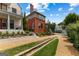 Beautiful brick home with manicured lawn featuring a decorative water feature and lush landscaping at 185 Central Ave, Fayetteville, GA 30214