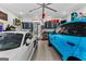 Well-equipped garage with two parked Porsche vehicles, overhead storage, and epoxy flooring at 185 Central Ave, Fayetteville, GA 30214