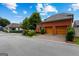 Brick two-car garage with wooden doors and a paved driveway, set against a backdrop of lush trees and a blue sky at 185 Central Ave, Fayetteville, GA 30214