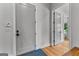 Hallway featuring gray doors, a blue patterned rug, and light hardwood floors at 185 Central Ave, Fayetteville, GA 30214