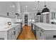 Bright kitchen featuring white cabinets, stainless steel appliances, an island, and wood floors at 185 Central Ave, Fayetteville, GA 30214