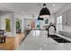 Kitchen island with quartz countertop, seating, and sink featuring views to the open concept living area at 185 Central Ave, Fayetteville, GA 30214