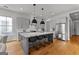 Stylish kitchen featuring gray cabinetry, quartz countertops, a large island, and stainless steel appliances at 185 Central Ave, Fayetteville, GA 30214