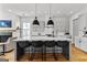 Bright kitchen with gray cabinets, a large island with seating, and a view of the living room at 185 Central Ave, Fayetteville, GA 30214