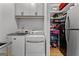 Functional laundry area with washer, dryer, shelving, and storage with stainless steel sink at 185 Central Ave, Fayetteville, GA 30214