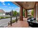 Relaxing covered porch with comfortable seating, brick flooring, and neighborhood views at 185 Central Ave, Fayetteville, GA 30214