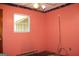 Bedroom with window, orange walls, and damaged flooring at 8469 Shiloh Ct, Jonesboro, GA 30238