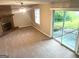 Cozy living room featuring a brick fireplace, sliding glass door to the backyard, and neutral carpet at 4196 Lehigh Blvd, Decatur, GA 30034