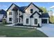 A two-story home boasts a well manicured lawn, a modern architectural style, and an attached garage at 1291 E M Croy Rd, Sugar Hill, GA 30518
