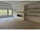 Bright living room featuring a modern fireplace and floating shelves creating a cozy, stylish area at 1291 E M Croy Rd, Sugar Hill, GA 30518