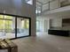 Bright, open-concept living space featuring large windows, a fireplace, and an adjacent unfinished kitchen at 1291 E M Croy Rd, Sugar Hill, GA 30518