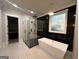Modern bathroom with a freestanding tub, glass shower, black marble accents, and sleek fixtures at 1293 E M Croy Rd, Sugar Hill, GA 30518