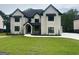 Stunning new construction home features a white brick facade, black trim, and professionally landscaped yard at 1293 E M Croy Rd, Sugar Hill, GA 30518