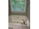 Bathroom featuring a jacuzzi tub, a window, and chrome faucets at 2074 Ayers Creek Ct, Villa Rica, GA 30180
