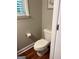 Bathroom featuring a toilet and a window, and a hardwood floor at 2074 Ayers Creek Ct, Villa Rica, GA 30180