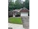 Charming single-story brick home featuring a two-car garage and well-maintained landscaping in a lush, green setting at 2074 Ayers Creek Ct, Villa Rica, GA 30180