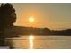 Scenic lake view with the sun setting in the background, reflecting on the water's surface at 2074 Ayers Creek Ct, Villa Rica, GA 30180