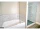 Bathroom showcasing a spa tub and a glass-enclosed shower with marble tiling at 638 Mcgruder Ne St, Atlanta, GA 30312