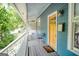 Inviting front porch with a cozy seating area, a yellow front door, and wood-paneled flooring at 638 Mcgruder Ne St, Atlanta, GA 30312