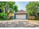 Detached two car garage in blue with a white door, surrounded by a lush tree line at 638 Mcgruder Ne St, Atlanta, GA 30312