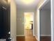 Hallway featuring hardwood floors, leading to the kitchen with views of white cabinetry and appliances at 345 Fond Du Lac Dr, Stone Mountain, GA 30088