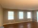 Bright living room featuring hardwood floors and three large windows with mini blinds for natural light at 345 Fond Du Lac Dr, Stone Mountain, GA 30088