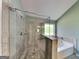 Modern bathroom featuring a large walk-in shower and a soaking tub near a window at 3507 Hideaway Ln, Loganville, GA 30052