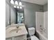 Bathroom featuring a well-lit vanity, mirror, and commode near a shower-tub combo at 3507 Hideaway Ln, Loganville, GA 30052