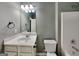 Bathroom featuring a well-lit vanity, mirror, and commode near a shower-tub combo at 3507 Hideaway Ln, Loganville, GA 30052
