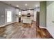 Open kitchen layout with stainless steel appliances, granite countertops, island, and hardwood floors at 3507 Hideaway Ln, Loganville, GA 30052