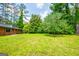 Lush backyard with views of brick home and mature trees, great for Gathering activities and enjoying nature at 3219 W Manor Ln, Atlanta, GA 30311