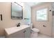 Modern bathroom with gray vanity, sleek fixtures, and a square mirror at 3219 W Manor Ln, Atlanta, GA 30311